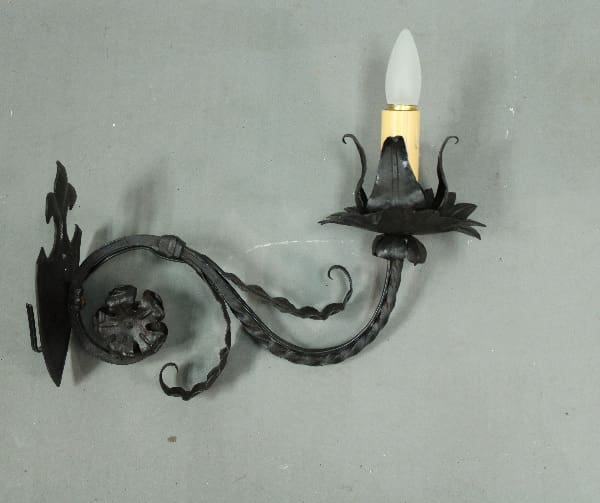 Wrought iron wall sconce with candlelight.