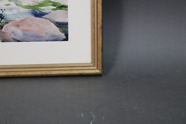 Framed watercolor painting of rocks and greenery.