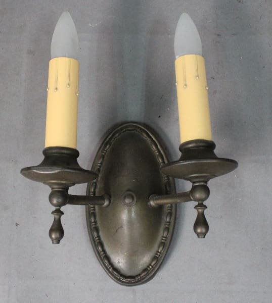 Wall sconce with two candle-like lights.