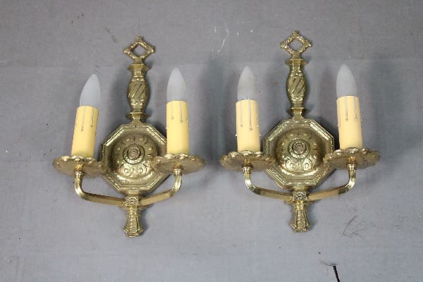 Brass wall sconces with candle-like bulbs.