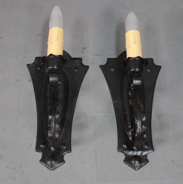 Two black candle holders with white bulbs.