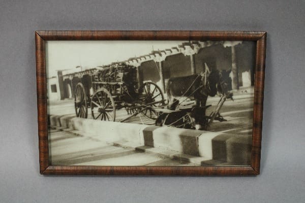 Old horse-drawn carriage in black and white.