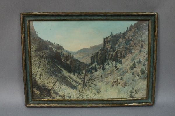 Mountainous landscape painting in ornate frame.