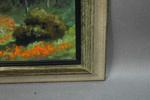 Framed painting with vibrant orange flowers.