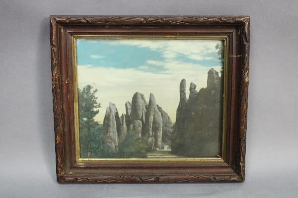 Framed landscape with rocky formations and sky.