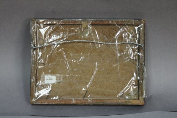 Framed item wrapped in plastic, backside view.