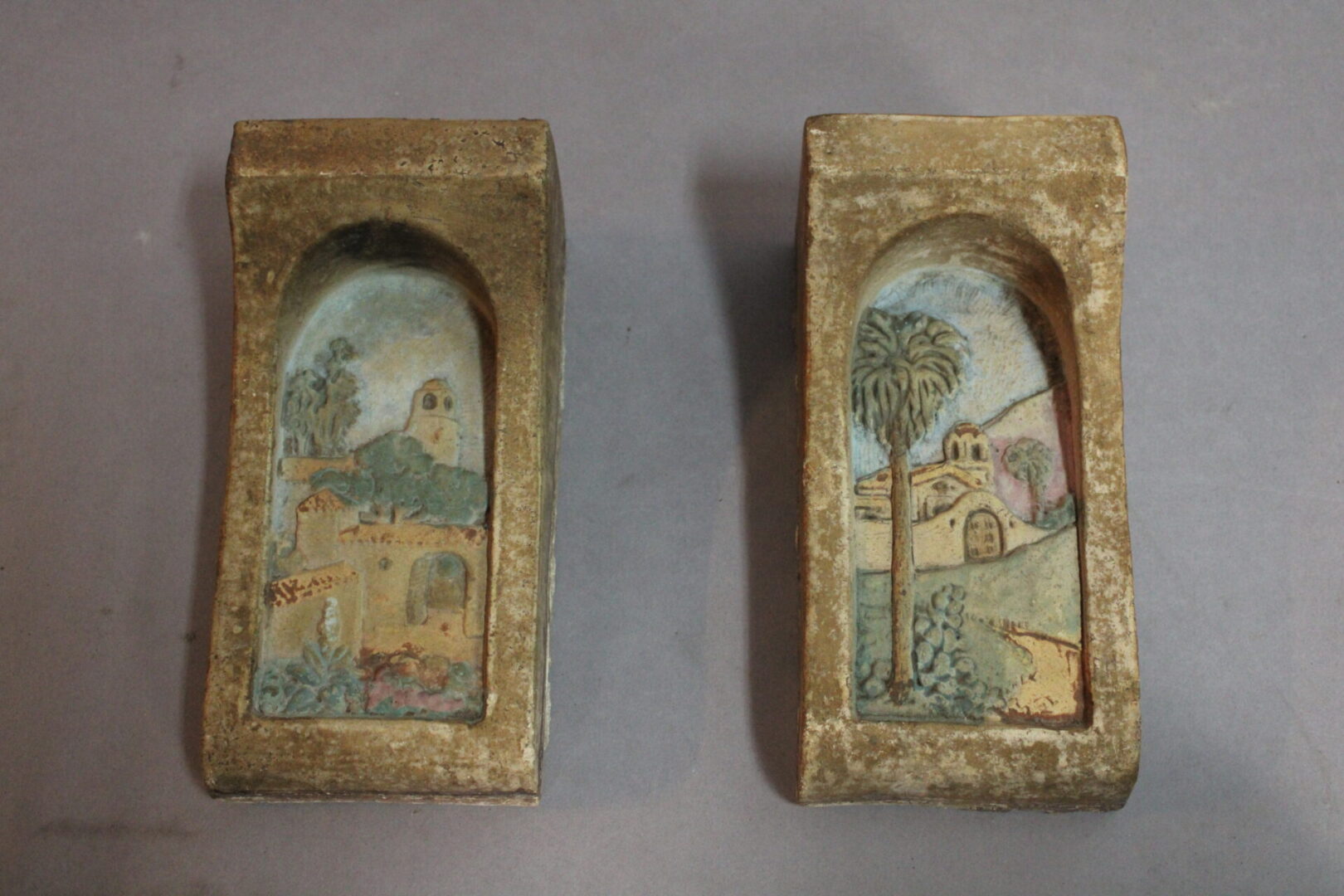 Two ceramic tiles with painted scenes.