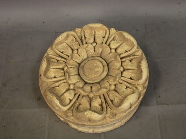 Stone carving of a flower with petals.