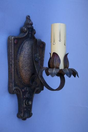Ornate wall-mounted candlelight fixture.