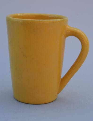 Yellow ceramic mug with a handle.