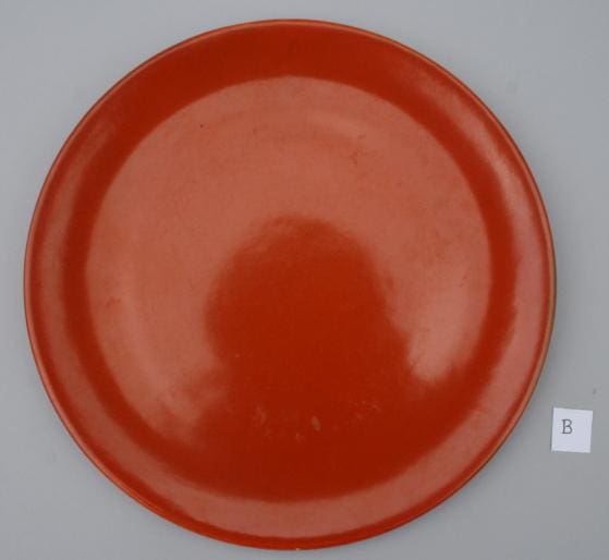 Red ceramic plate on gray background.