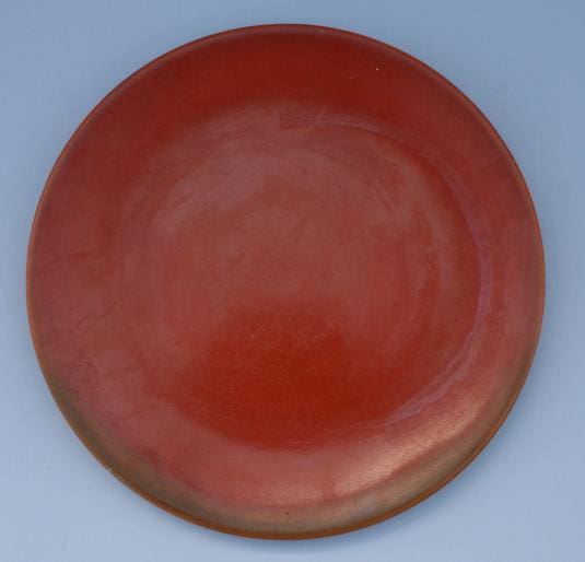 Red ceramic plate on blue background.