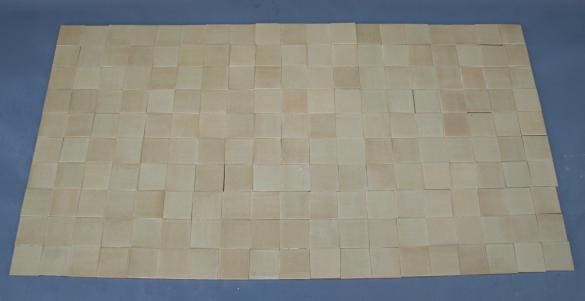 Grid of beige square tiles on floor.