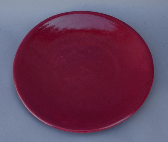 Red ceramic plate on gray background.