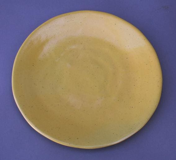 Yellow ceramic plate on blue background.