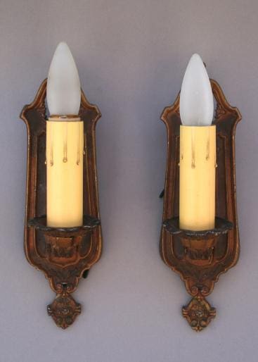 Two vintage wall sconces with candles.