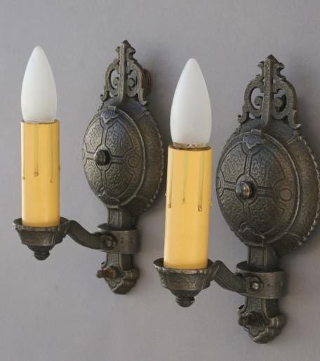 Two vintage wall sconces with yellow candles.