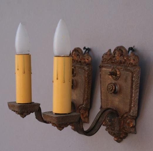 Vintage wall sconce with yellow candle holders.