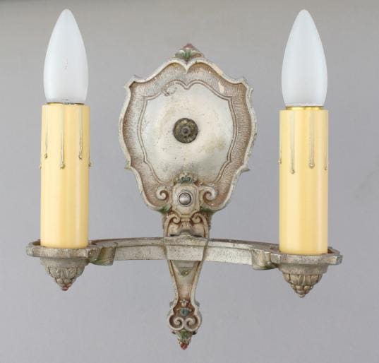 Antique wall sconce with two candle holders.