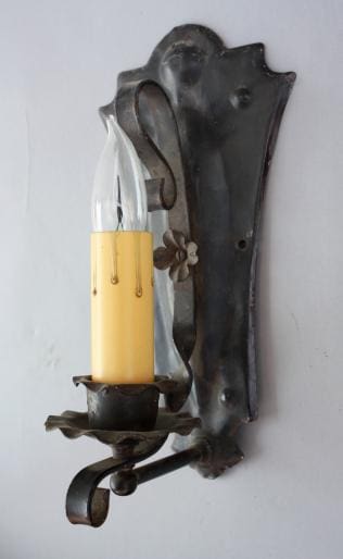 Vintage wall sconce with yellow candle bulb.