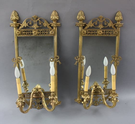 Pair of ornate gold sconces with mirrors.