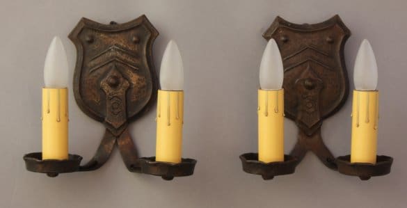 Two candle wall sconces on a gray background.