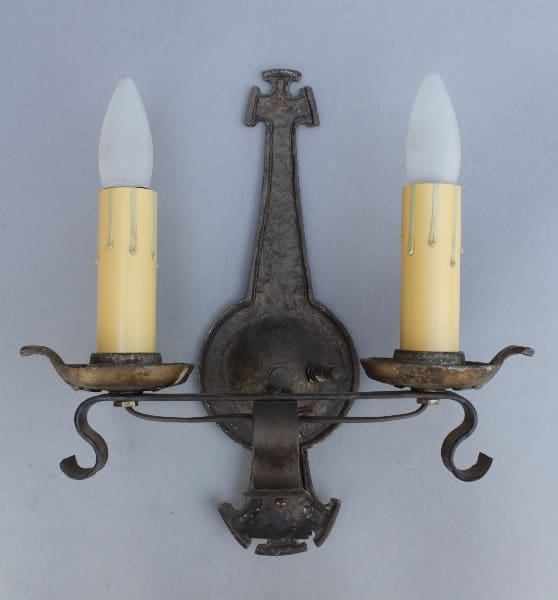 Wall-mounted candle holder with two candles.