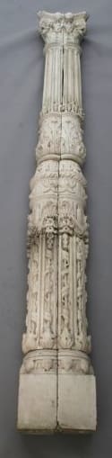 Detailed ornate pillar sculpture against a gray background.
