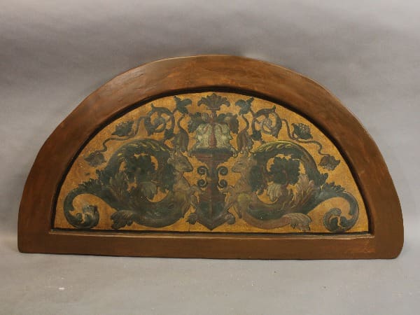 Semi-circular wooden panel with ornate design.