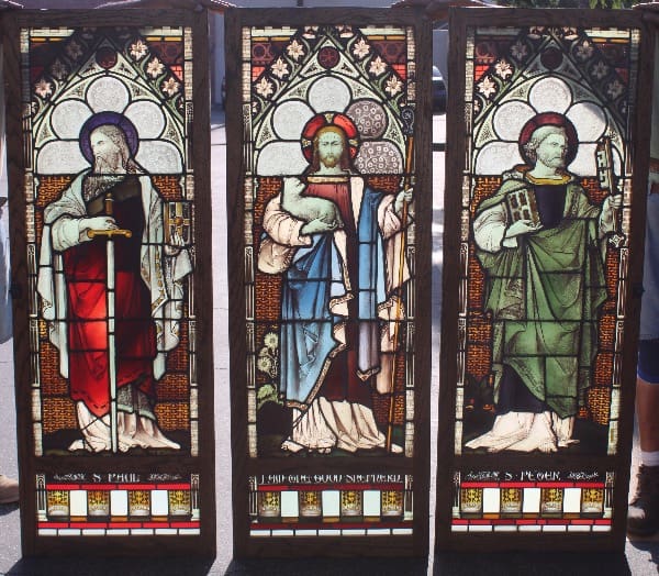 Three stained glass panels with religious figures.