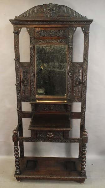 Ornate wooden hall stand with mirror.