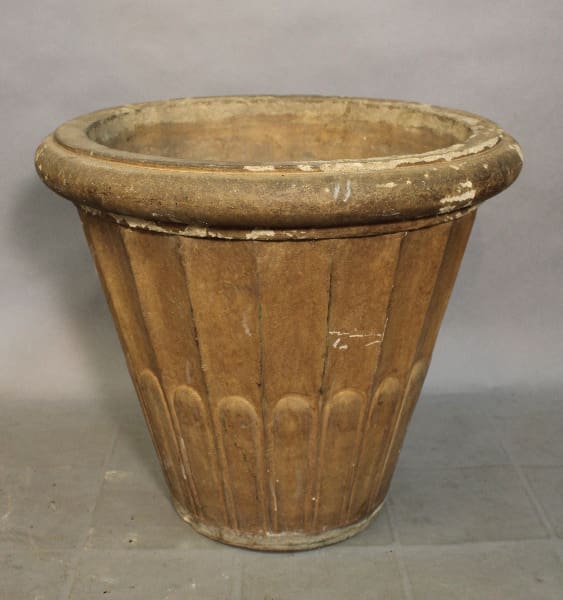 Large, weathered terracotta planter on floor.