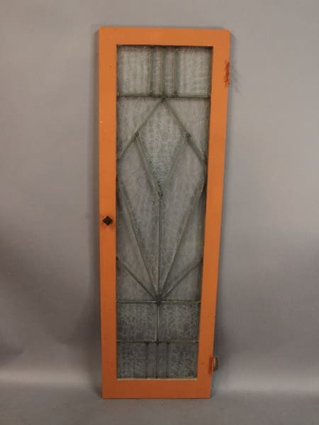 Orange-framed glass door with geometric design.