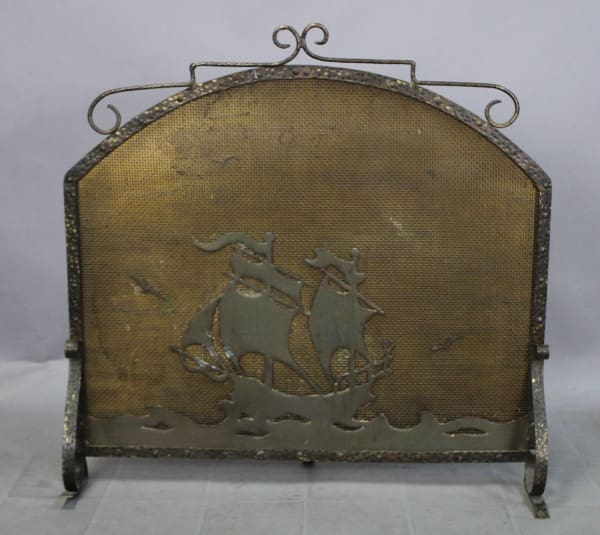 Metal fireplace screen with ship design.