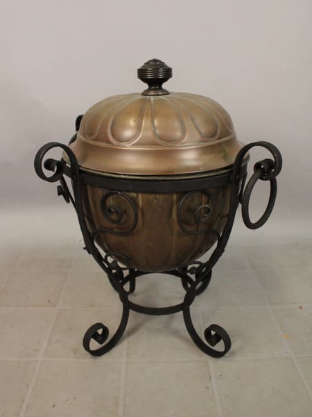 Decorative metal urn with ornate stand.