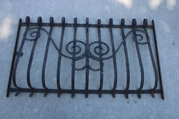 Ornate metal gate with swirl design.