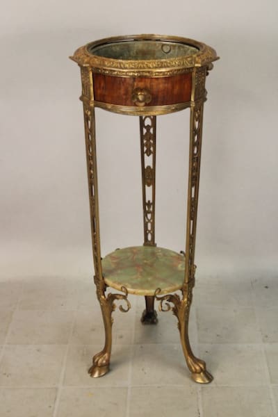 Ornate antique plant stand with marble shelf.
