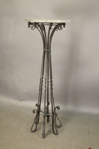 Ornate metal plant stand with marble top.