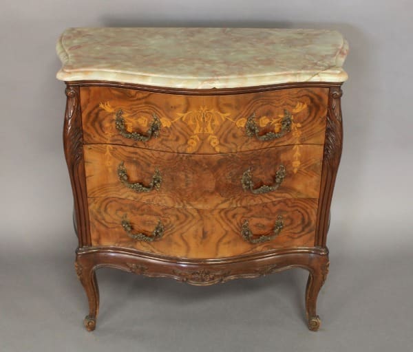 Vintage wooden dresser with ornate handles.