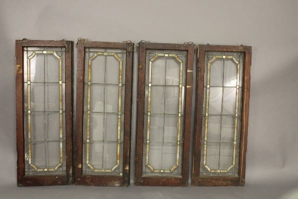 Four vintage stained glass window panels.