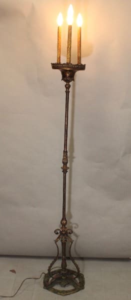 Tall antique floor lamp with glowing bulbs.
