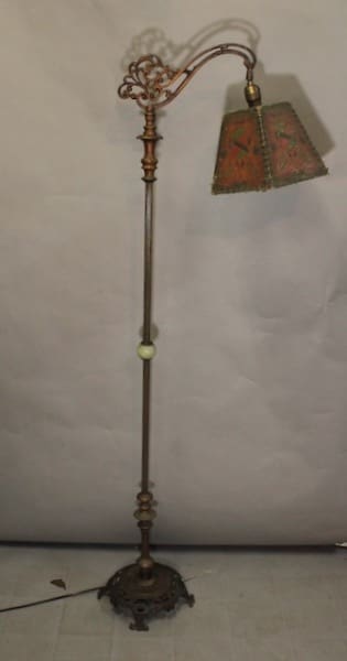 Antique standing lamp with ornate lampshade.