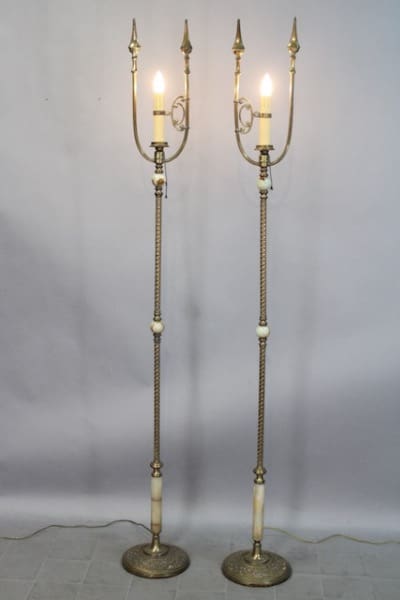 Two ornate standing lamps with lit bulbs.