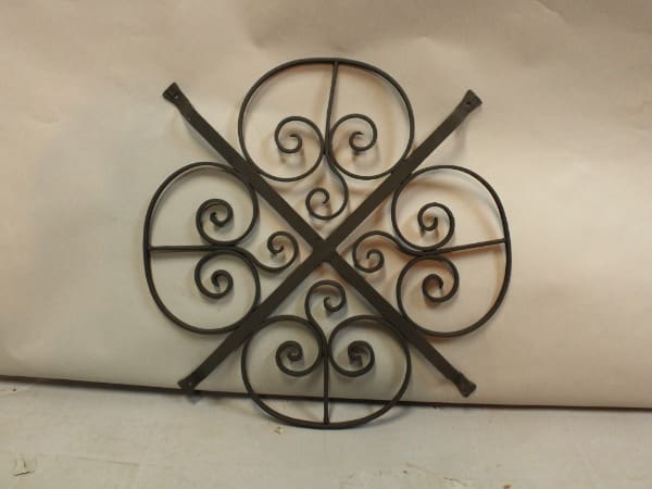 Decorative metal wall art with swirling patterns.