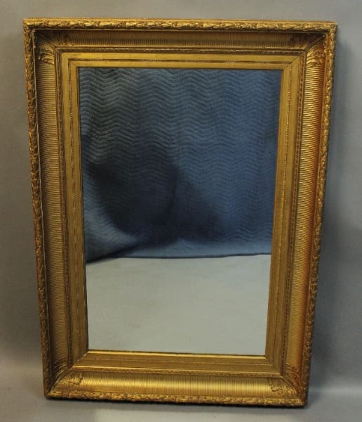 Gold-framed mirror with ornate detailing.
