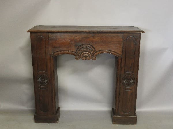 Vintage wooden fireplace mantel with carved details.