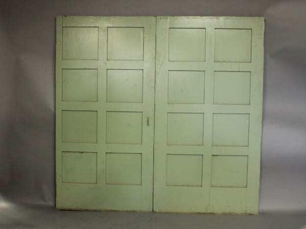 Green double doors with square panels.