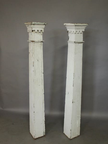 Two vintage white wooden architectural columns.