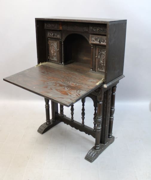 Antique wooden writing desk with ornate carvings.