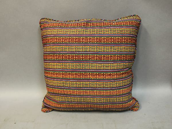 Colorful patterned pillow with tribal design.